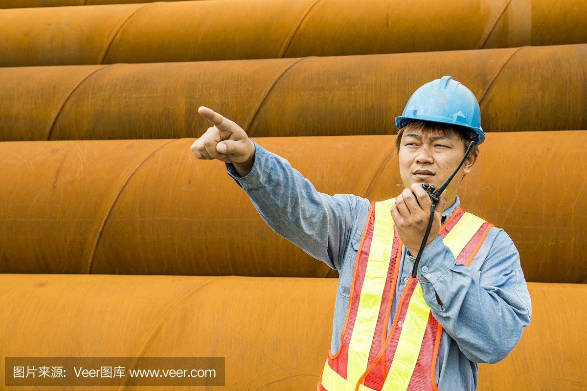 建筑工人在起重機的背景下檢查現(xiàn)場